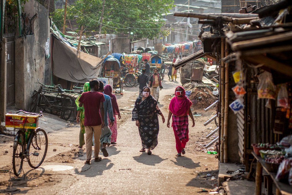 Mujeres con las máscaras por la pandemia de Covid 19 caminando por un mercado de Dhaka.